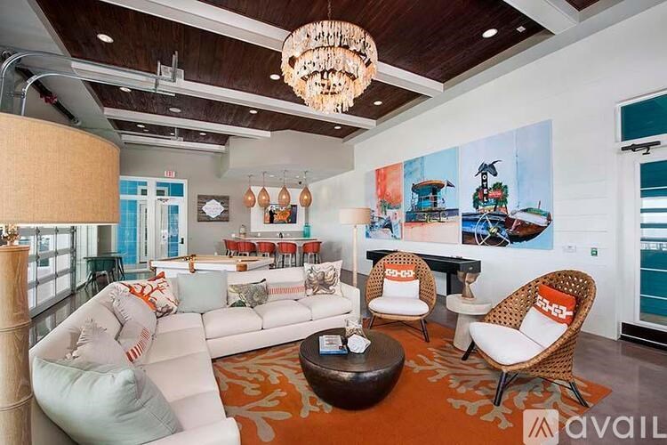 A living room with a white couch and a chandelier.