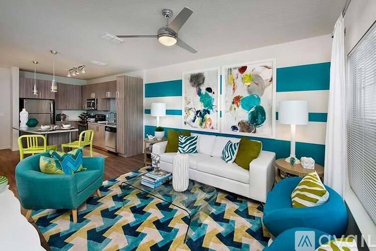 A living room with a white couch and a blue chair.