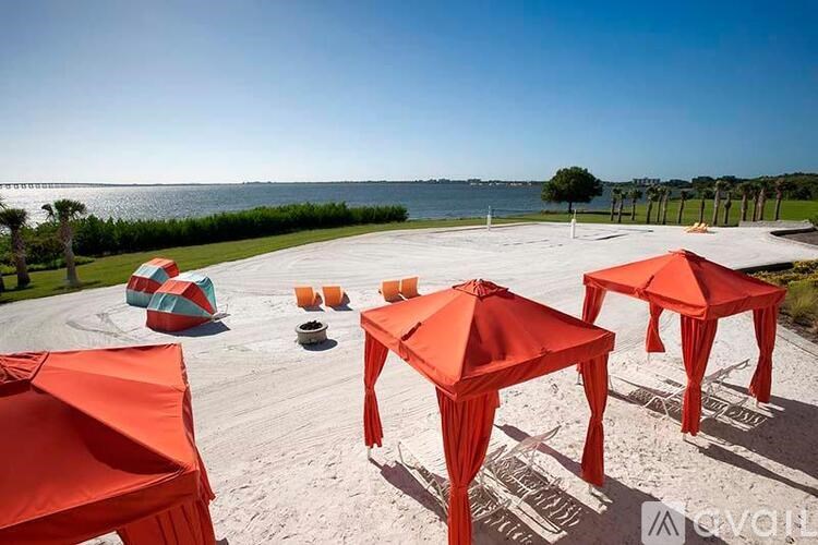A set of orange umbrellas are arranged on a concrete surface.