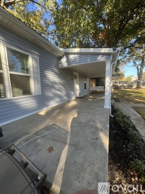 A house with a grey siding and a white porch.