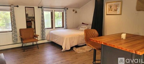 A room with a bed, a chair, and a table.