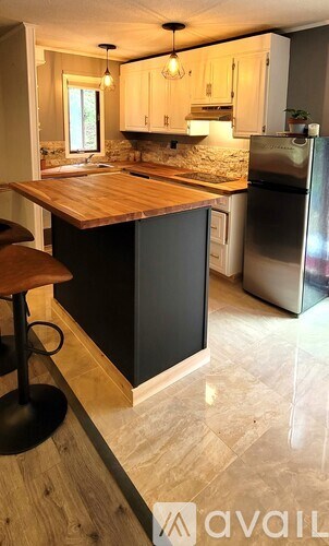A shower stall with a glass door and a brown mat on the floor.