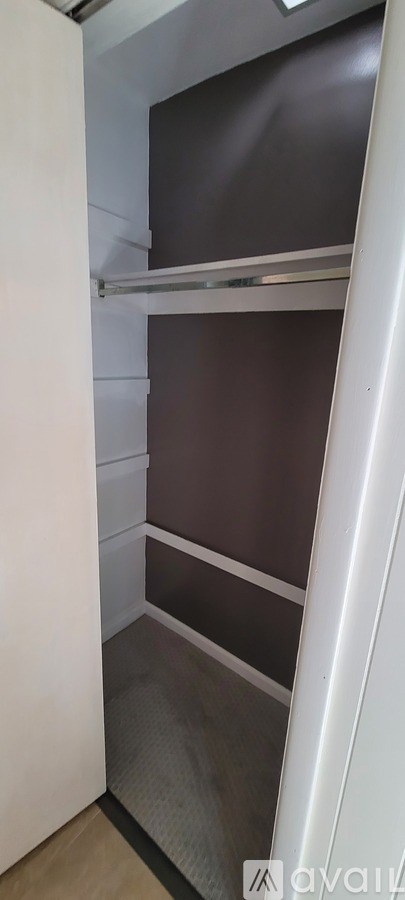 A small, empty kitchen with a refrigerator and a cabinet.