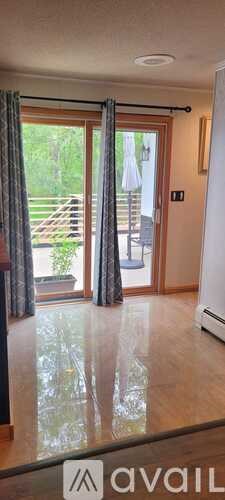 A room with a sliding glass door and a wooden floor.