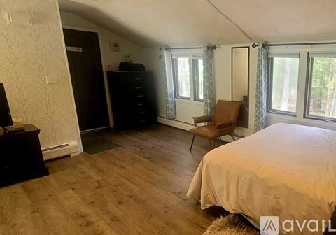 A bedroom with a bed, chair, and wardrobe.