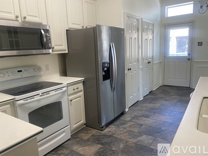 A kitchen with a stainless steel refrigerator, microwave, and oven.
