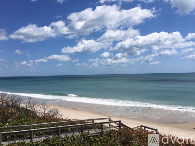 A beach with a wooden walkway leading to the shore.