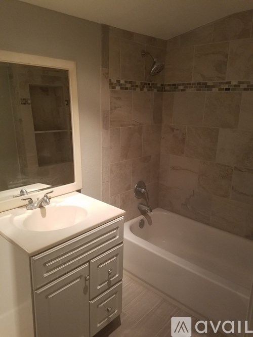 A bathroom with a white sink and a bathtub.