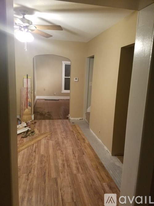 A room with wooden flooring and a ceiling fan.