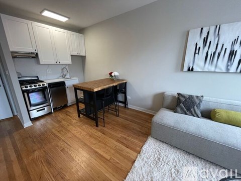 A kitchen with a stove top oven and a dining table with chairs.