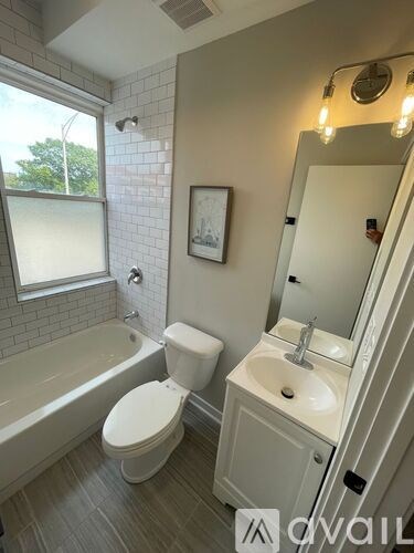 A bathroom with a toilet, sink, and tub.