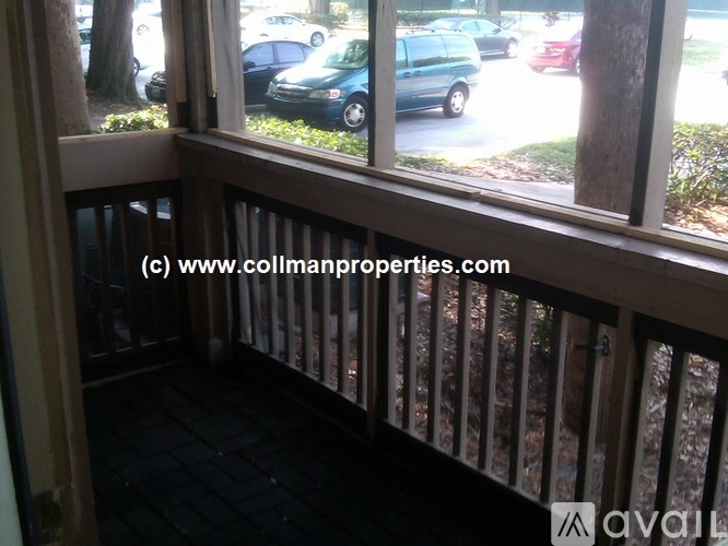 A balcony with a view of cars and trees outside.