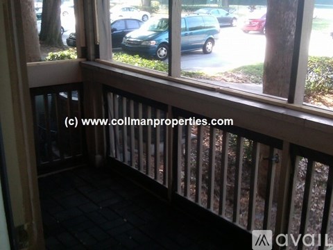 A balcony with a view of cars and trees outside.