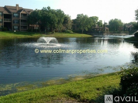 A fountain in the middle of a lake surrounded by grass.