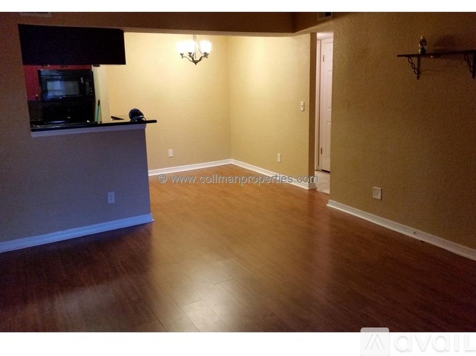 A room with wooden floors and a television on a counter.