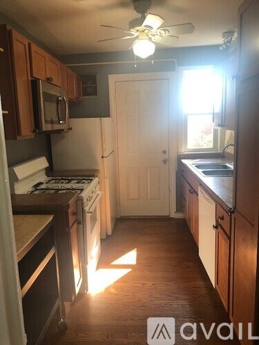 A kitchen with wooden cabinets and a white door.
