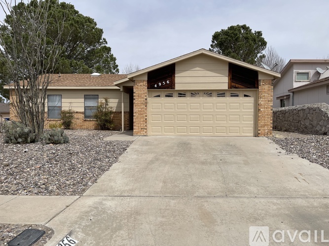 A house with a garage and a driveway in front of it.