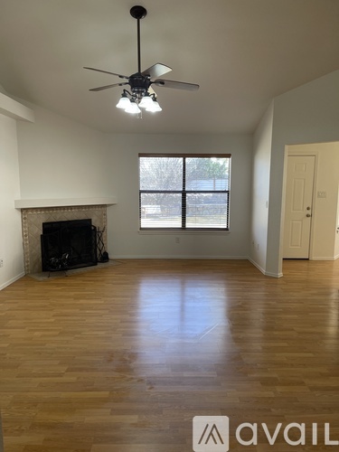 A room with a fireplace and a ceiling fan.