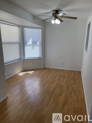 A room with wooden flooring and a ceiling fan.