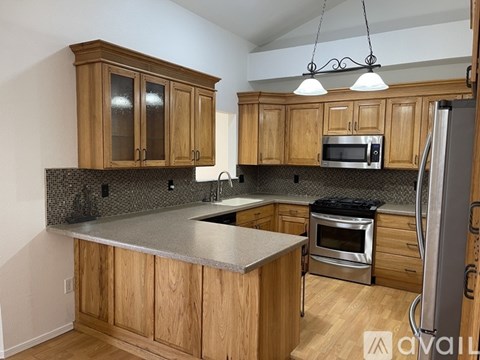 A kitchen with wooden cabinets and a granite countertop.