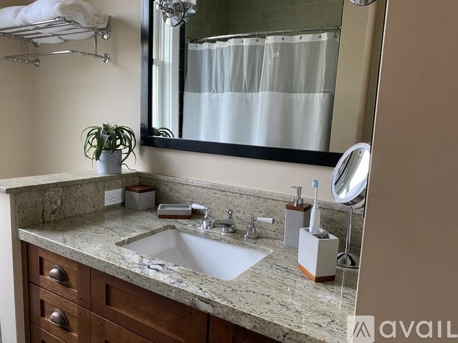 A bathroom with a marble countertop and a large mirror.