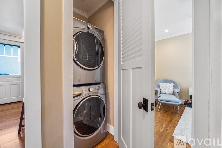 A modern laundry room with a washer and dryer built into the wall.