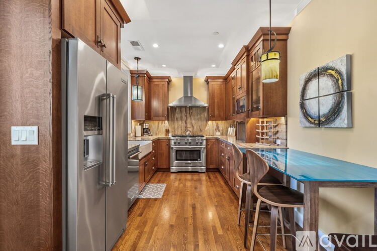 A modern kitchen with wooden cabinets and a stainless steel refrigerator.