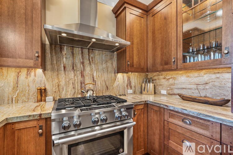 A kitchen with a stove and wooden cabinets.
