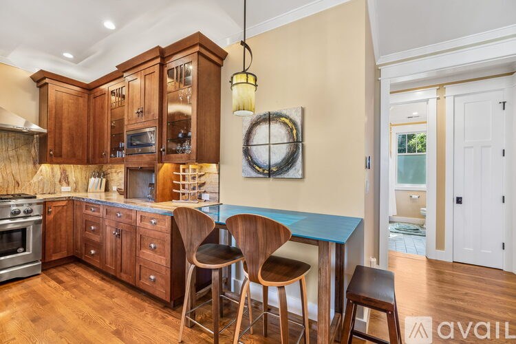 A kitchen with wooden cabinets and a blue island.