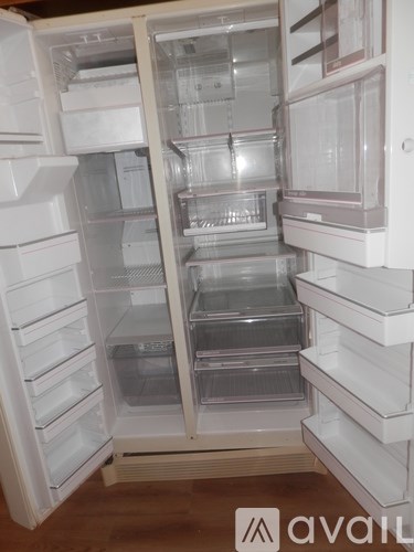 A white refrigerator with its door open and shelves visible.