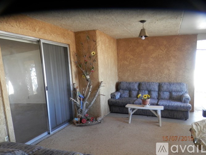 A living room with a grey sofa and a glass door.