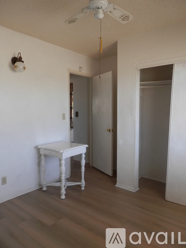 A room with a table and a ceiling fan.