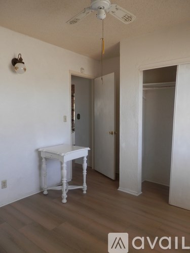 A room with a table and a ceiling fan.
