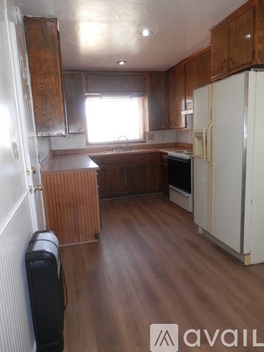 A kitchen with wooden cabinets and a white fridge.