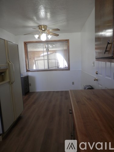 A room with a wooden floor and a ceiling fan.