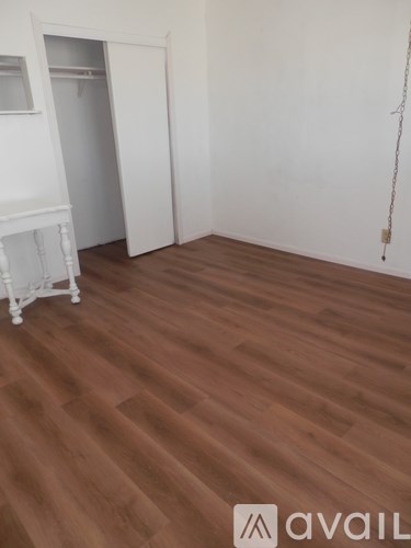 A room with wooden flooring and a white cabinet.