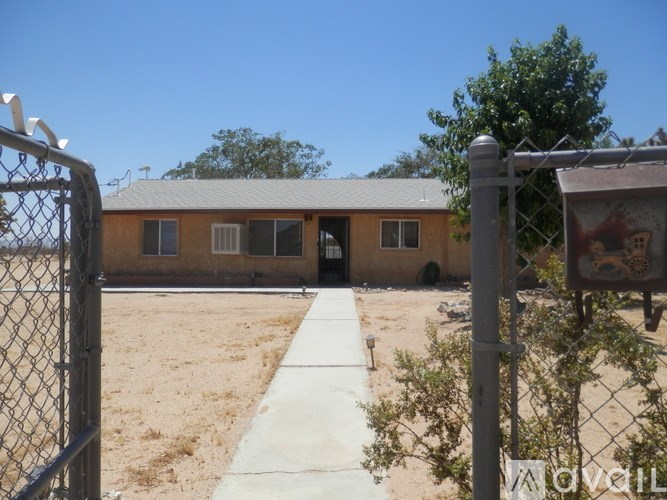 A chain link fence with a gate is in front of a building with a sign that reads "LOVE".