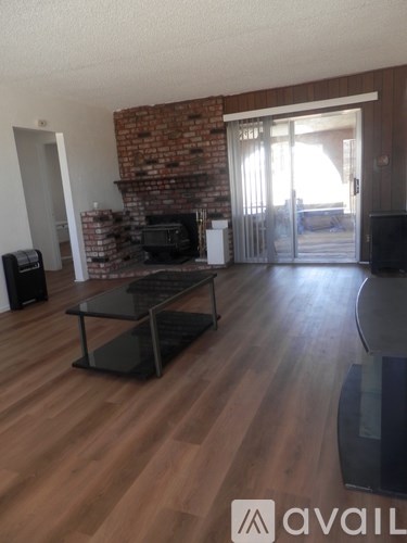 A living room with a brick wall and wooden floors.