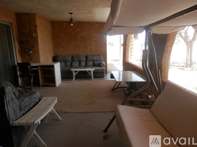 A living room with a grey couch and a white bench.