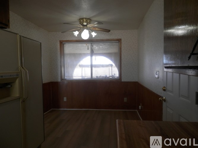 A room with a ceiling fan and a window with blinds.