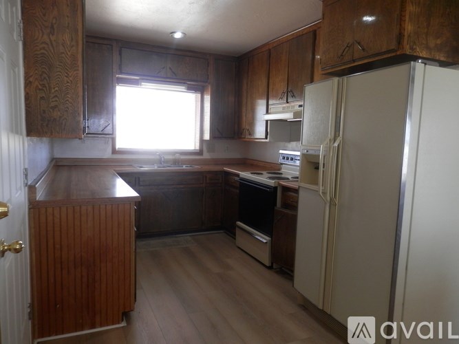 A kitchen with wooden cabinets and a white refrigerator.