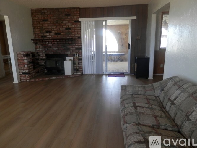 A living room with a brick fireplace and a couch.