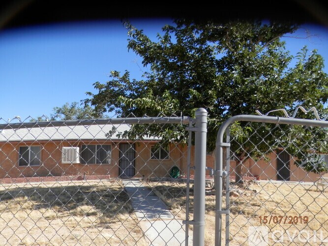 A chain link fence with a building in the background.