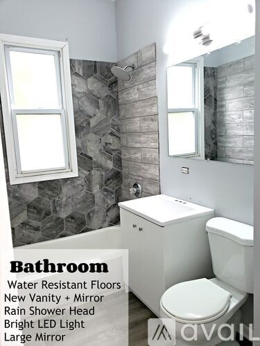 A bathroom with a toilet, sink, and a mirror.