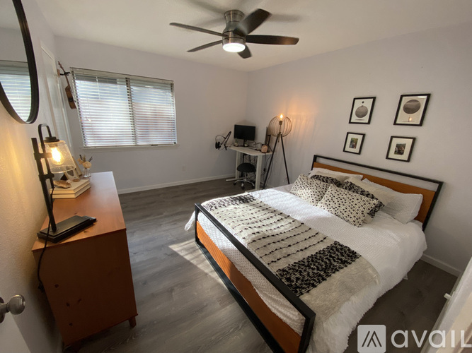 A bedroom with a bed, a dresser, and a ceiling fan.
