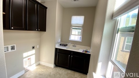 A kitchen area with black cabinets and a window.