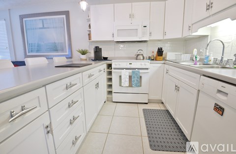 A kitchen with white cabinets and appliances.