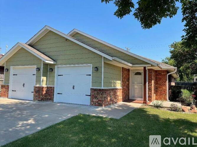A house with a beige siding and a white garage door is for sale.