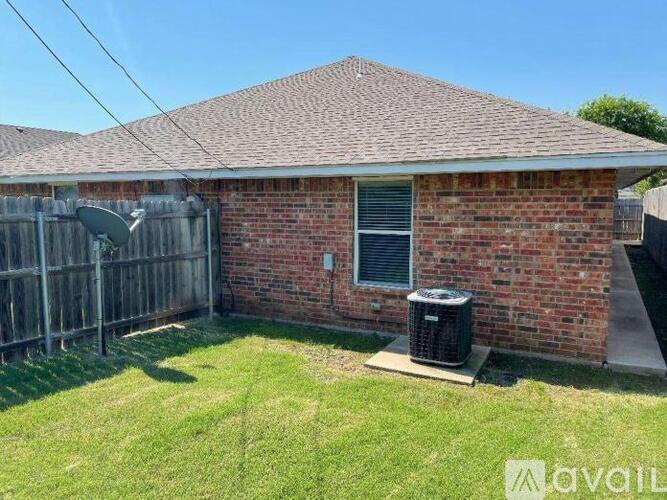 A house with a brown roof and a brick wall with a window and a satellite dish.