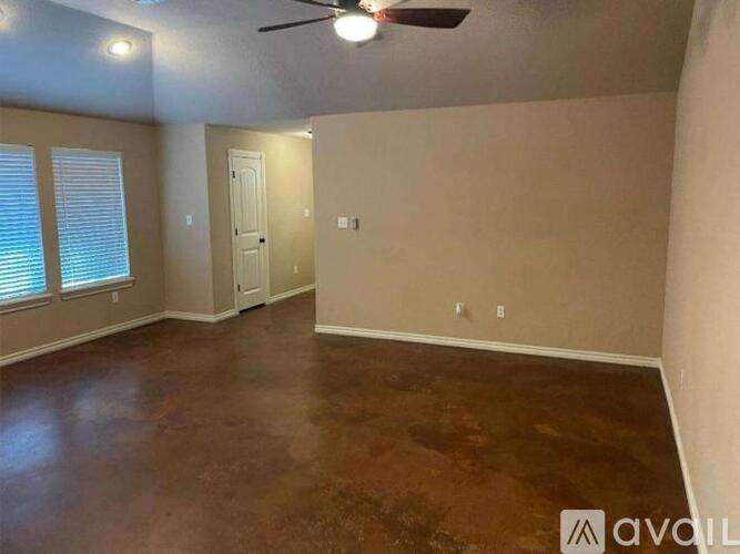 A room with a ceiling fan and a door.